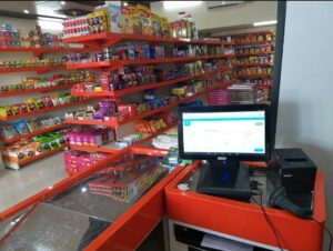 Cash Counter - For every Store, billing counter or cash counter is the underrated item. and Mild Steel Racks, Display Racks in Meerut, Customized Racks for Shop, including a counter in orange and stainless steel and shop is filled with daily use items